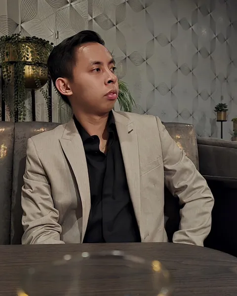 Kent Caparas in a cream blazer, seated at a table